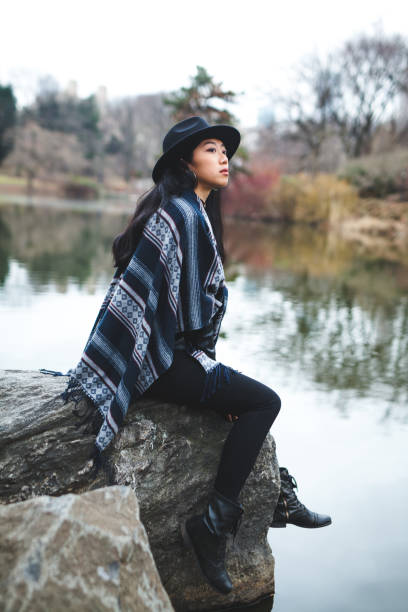 istock Asian woman sitting on a rock 1138718257