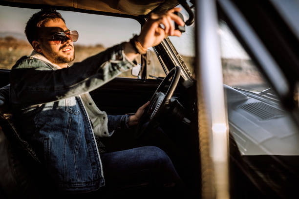 istock Handsome man driving car in sunset 1138720757