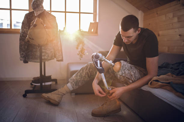 Soldier with prosthetic leg putting on military boots