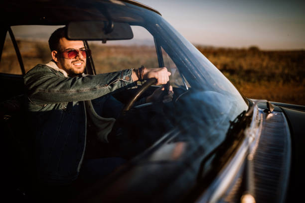 istock Handsome man driving car in sunset 1138720830