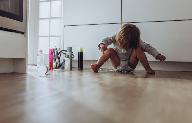 istock Kid sitting on floor at home playing with cosmetic bottles 1138720988