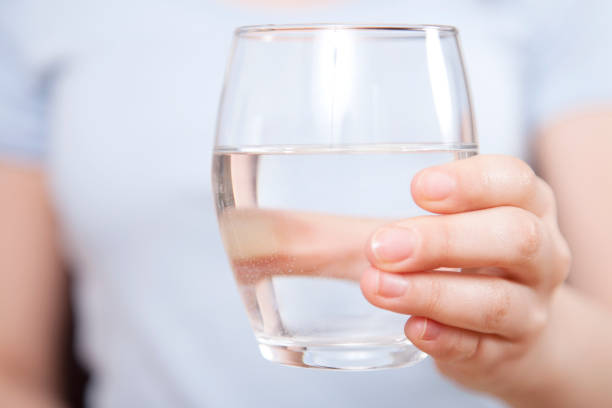 istock Woman is hand holding drinking water on gray background 1138721047