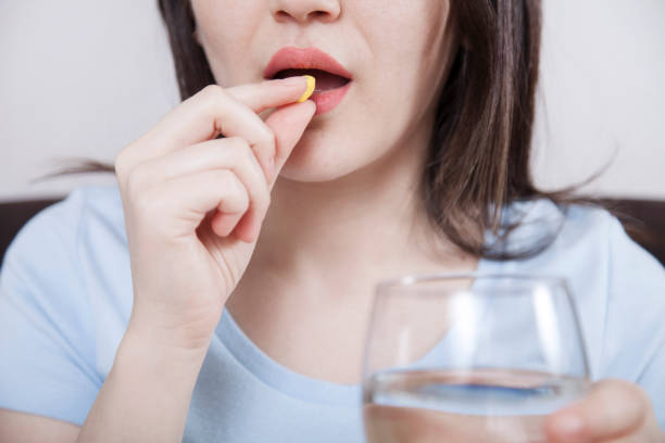 istock Young woman taking a pill 1138721169