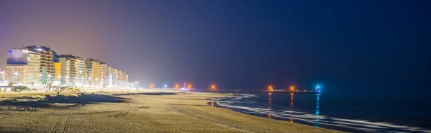 de kust van blankenberge verlicht in de nacht, populaire en toeristische bestemmingen in belgië, stadsarchitectuur verlicht in het donker - blankenberge strand stockfoto's en -beelden