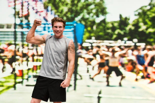 istock Handsome man is standing at an outside sporting event and cheering 1138725718