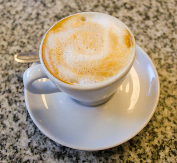 istock A  small  white cup of coffee at a bar table closeup. 1138729020