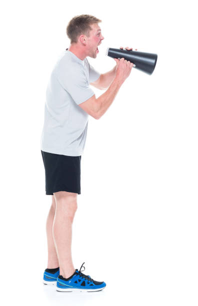 istock Attracitve man in sports clothing using a small megaphone 1138730199