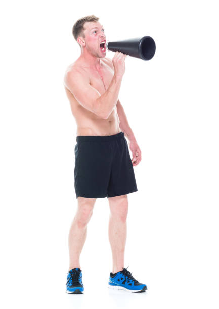 istock Handsome shirtless man is yelling into a megaphone 1138730263