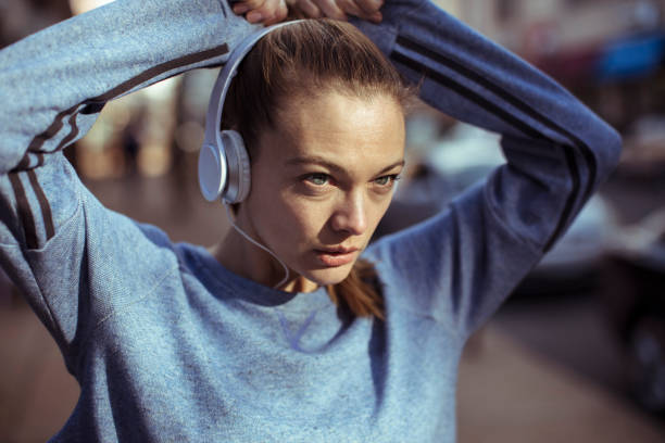 Getting Ready Close up of a woman tying her hair before jogging woman tying hair in ponytail getting ready for exercising stock pictures, royalty-free photos & images