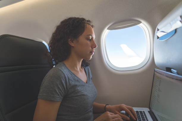 istock Traveler on airplane working on her laptop 1138733087