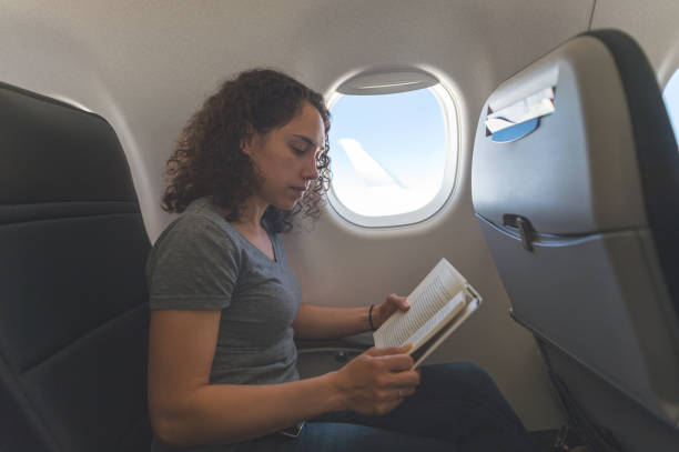 istock Female traveler reading a book on the airplane 1138733089