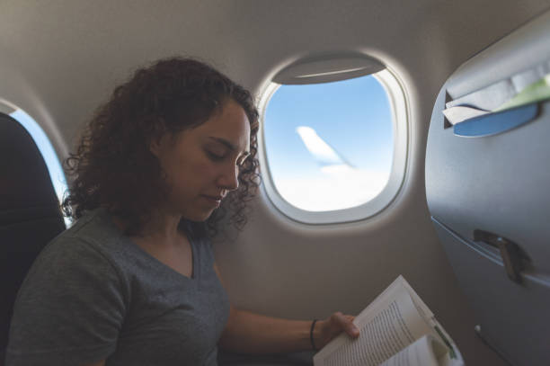 istock Female traveler reading a book on the airplane 1138733092