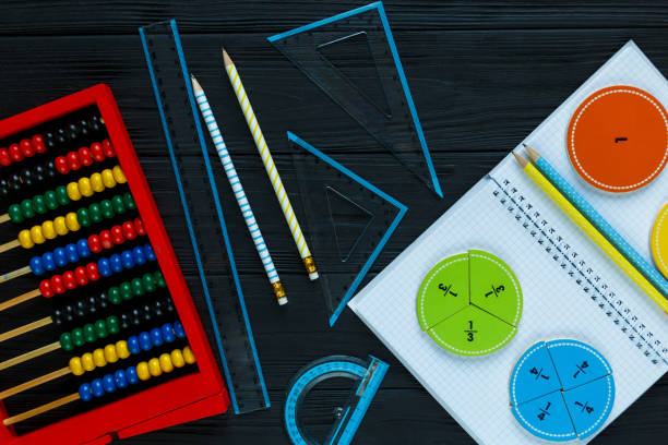 istock Colorful math fractions on dark wooden background or table. Interesting math for kids. Education, back to school concept. Geometry and mathematics materials. 1138733965