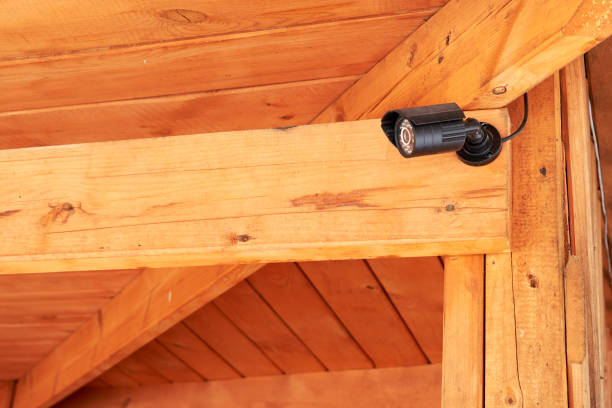 istock black security surveillance camera. CCTV camera mounted on a wooden house. security concept. 1138734068