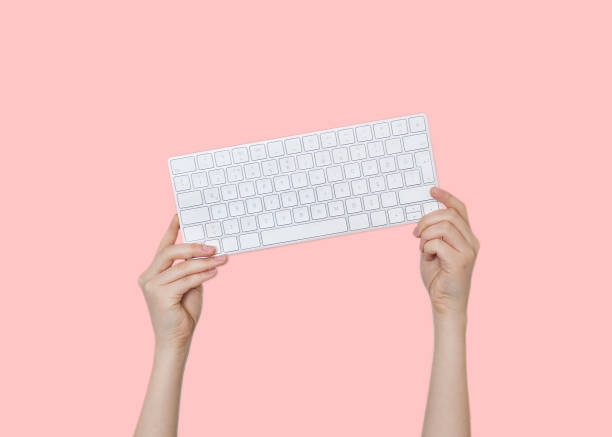 istock Raising hands with keyboard on pink background 1138735802