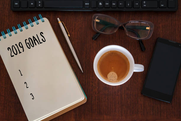 istock New year goals concept. Office desk with notebook, computer, coffee cup, smartphone and glasses 1138735901