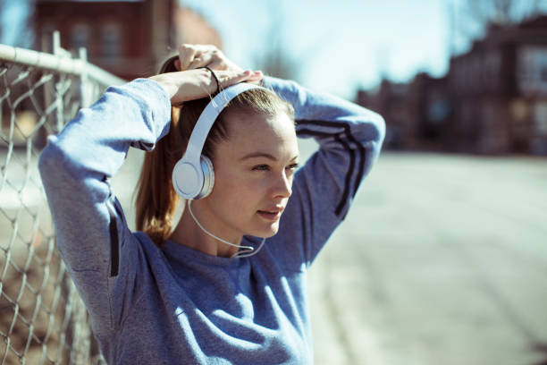 Getting Ready Close up of a woman tying her hair before jogging woman tying hair in ponytail getting ready for exercising stock pictures, royalty-free photos & images