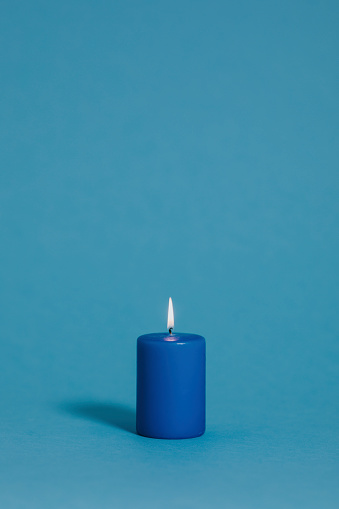Burning candle in blue color