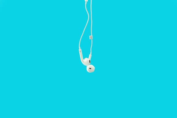 istock White hanging ear buds headphones isolated on a blue 1138745027