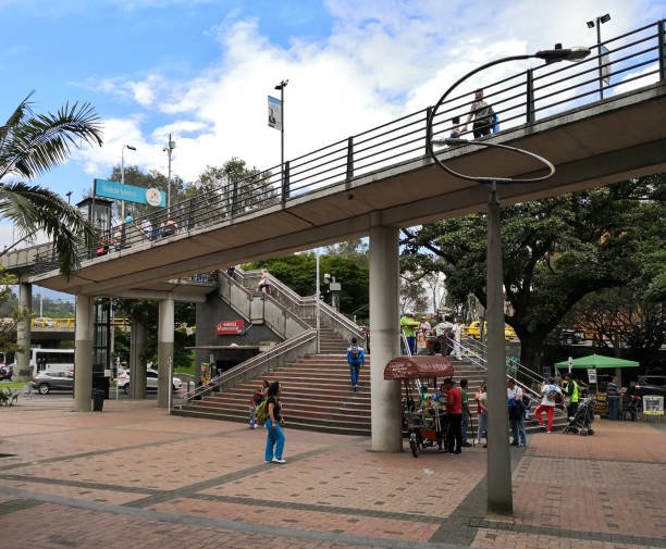 Square with steps to go up to a Medellin Metro station and Metroplus system Small square with steps to go up to the bridges that lead to a Medellin Metro station and the Metroplus bus system. Street vendors, people walking and details of the urban structure. Medellin, Colombia. metro medellin stock pictures, royalty-free photos & images