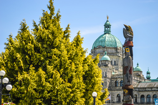 The Victoria government building beside an aboriginal totem pole.