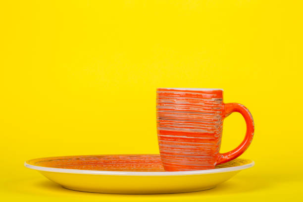 istock Table set of cups and plates on a yellow background 1138759095