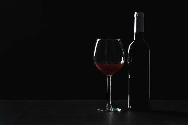 istock Bar Concept with a Wine Bottle, a Wine Glass and a Cocktail on a Black Background 1138759727