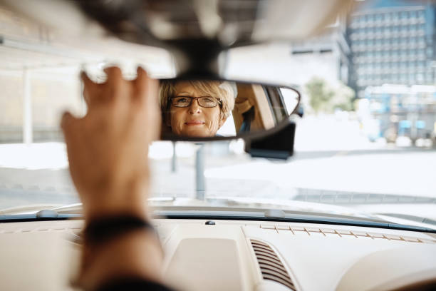 sie ist sicher, dass sie während der fahrt eine klare vision rund um sich hat - rear view mirror car mirror rear view stock-fotos und bilder