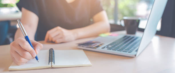 la mano della donna d'affari sta scrivendo su un blocco note con una penna. - pen paper document business foto e immagini stock