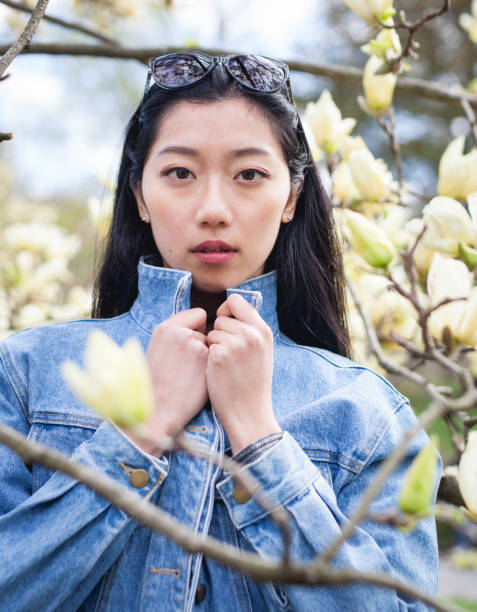 Asian girl surrounded by yellow spring flowers stock photo