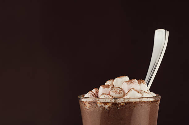 gourmet coffee drink in glass with marshmallows and silver spoon, closeup, top section, edge, detail on dark brown background, copy space. - hot chocolate hot drink high section close up imagens e fotografias de stock