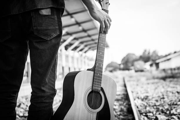 istock Guy with guitar on the railway road. Black and white photo 1138777314