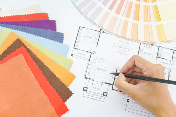 architects hands drawing of modern house with colors and material samples on creative desk stock photo