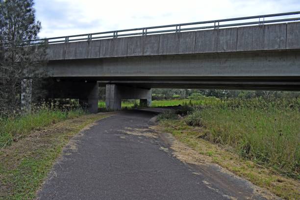 istock Single lane road underneath a highway bridge 1138782762