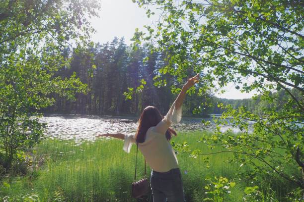 Young Asian woman happily lost in a forest