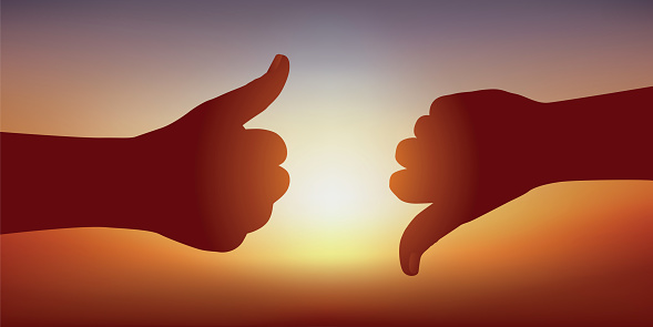 Concept of decision-making, with two gestures expressing contrary opinions. One hand, thumb in the air, gives a favorable opinion, another thumb pointed down, opposes it.