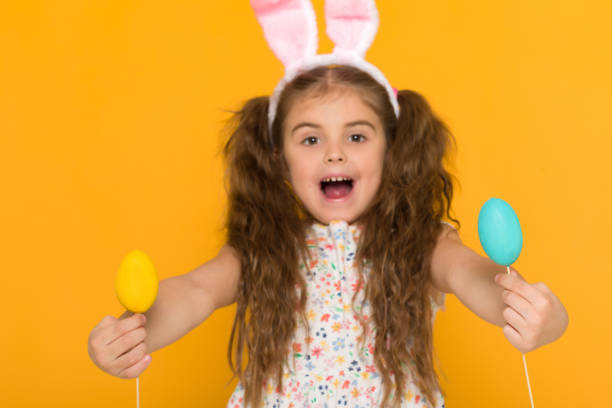istock cute little girl with Easter bunny ears holding colorful eggs 1138787475