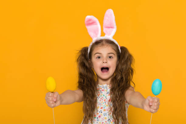istock cute little girl with Easter bunny ears holding colorful eggs 1138787559