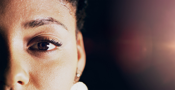 Closeup shot of a beautiful young woman's eye against a dark background