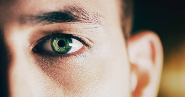 Looking at the future Closeup shot of  man opening his eyes against a dark background green eyes photos stock pictures, royalty-free photos & images