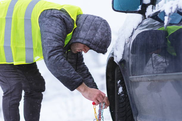 istock Man Putting Chain On Tire Of Car During Snow 1138790072