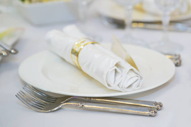 Beautifully elegant decorated table for holiday - wedding or valentine day with modern cutlery, bow, glass, candle and gift, closeup, toned