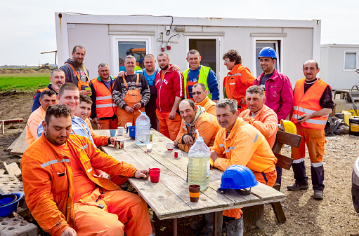 Zrenjanin, Vojvodina, Serbia - March 30, 2018: Construction workers are resting and enjoying in beverage among office containers at construction site.