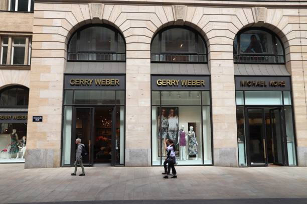 Gerry Weber People walk by Gerry Weber and Michael Kors at Grimmaische Street in Leipzig, Germany. Grimmaische Strasse is the heart of Leipzig's pedestrianized shopping area. halle north rhine westphalia stock pictures, royalty-free photos & images