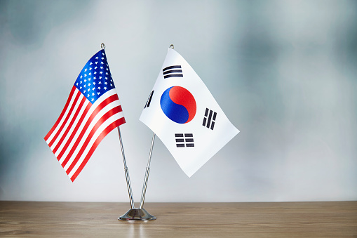 American and South Korean flag standing on the table with defocused background