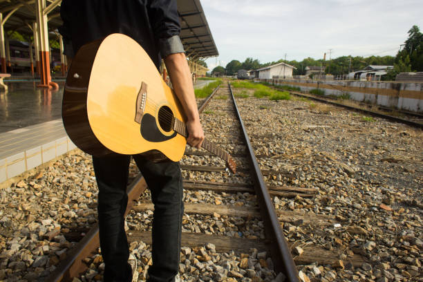 Guy with guitar on the railway road
