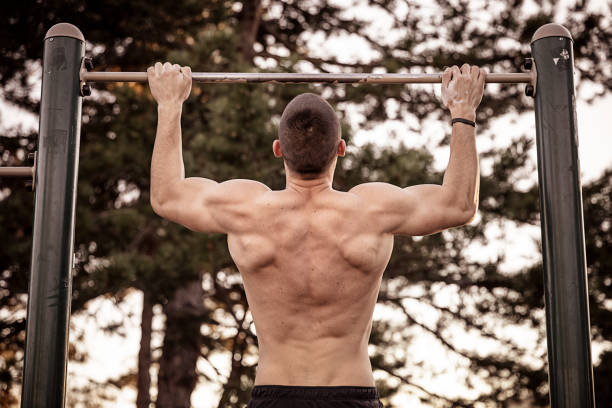 istock Handsome Young Athlete Doing Chin-ups on Horizontal Bar 1138807452