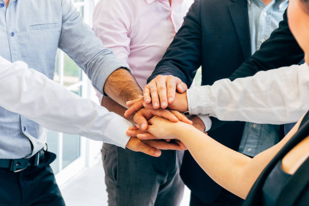 Business people putting hands togehter for unity stock photo