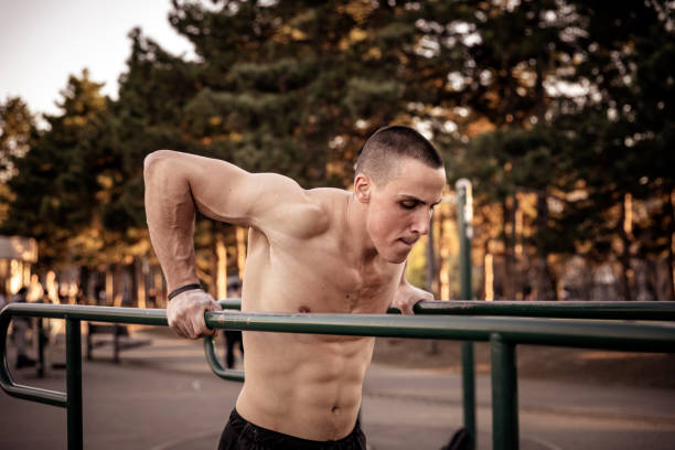 istock Young Muscular Athlete is Exercising On Horizontal Bars 1138808081