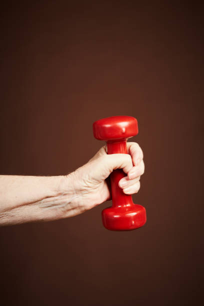 istock Senior hand holds barbell, keeping fit 1138809680